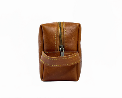 Brown leather toiletry bag on a white background
