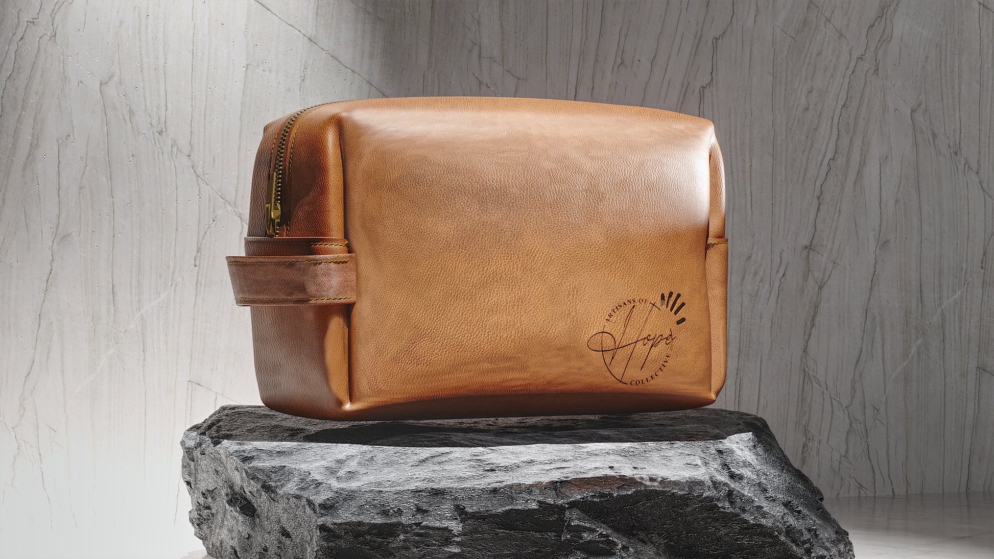 Brown leather toiletry bag with a brand logo on a rock against a marble background