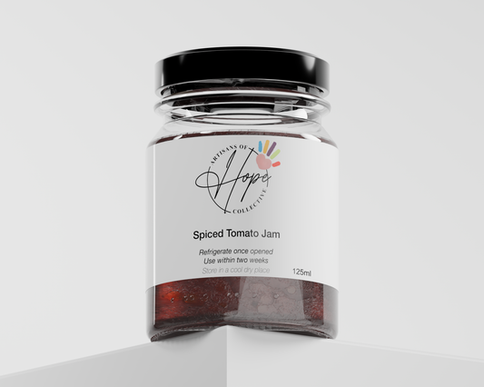 Jar of Spiced Tomato Jam with 'Artisans of Hope' label on a white background