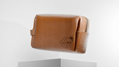 Brown leather toiletry bag with a brand logo on a white background